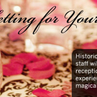 Elegant reception table with rose petals and glasses.