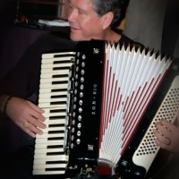 Person playing a piano accordion indoors.