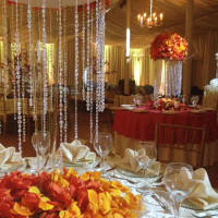 Elegant banquet tables decorated with autumn-themed floral arrangements and crystal strands.