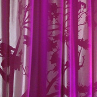 Purple and white curtains with floral shadows.